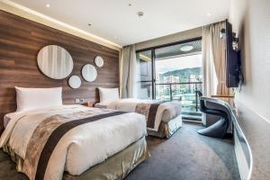 台北洛碁大饭店松山馆的配有窗户的酒店客房内的两张床