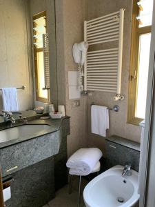 奥斯塔罗马酒店的一间带水槽、卫生间和镜子的浴室