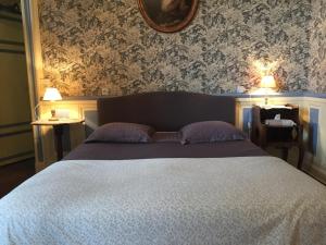Lussault-sur-Loire德宾泰木屋酒店的一间卧室配有一张床、两盏灯和一面镜子