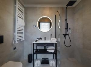 克拉科夫Hotel Estera的浴室配有盥洗盆和带镜子的淋浴
