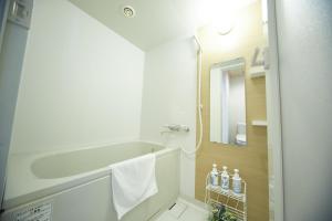 泉佐野泉佐野中心关西国际机场酒店的带浴缸、水槽和镜子的浴室