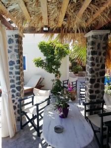 佩里萨5bedroom villa in perissa beach的庭院配有椅子和桌子及盆栽植物