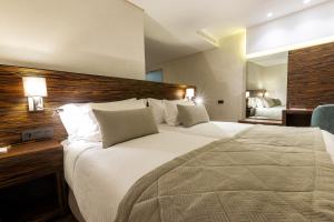 非斯Nour Plazza Hotel的酒店客房设有一张大床和一张书桌。