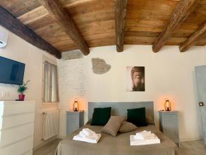 费拉拉Green Rooms Ferrara的一间带一张床的卧室,位于带木制天花板的房间内
