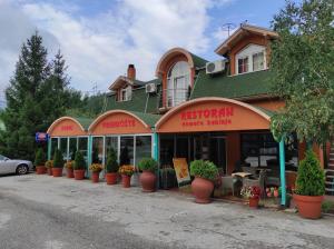 新瓦罗什Restoran Filipovic的建筑前有盆栽植物的商店
