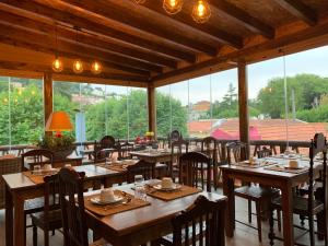 辛特拉Storytellers Villas的餐厅设有木桌、椅子和窗户。