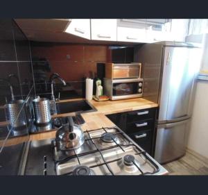 乌涅尤夫Apart Bella的厨房配有炉灶和不锈钢冰箱。