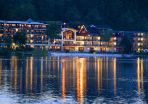 普莱西德湖金箭湖畔度假酒店的湖岸上一座大建筑
