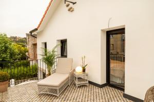 苏安塞斯La Playa Suites Suances的阳台的庭院配有白色椅子