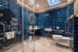StetchworthThe Three Blackbirds的蓝色瓷砖浴室设有卫生间和水槽