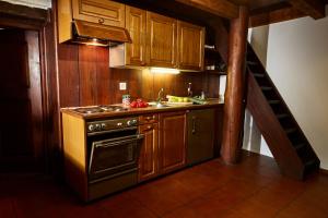CranaWild Valley Romantic Escape的厨房配有木制橱柜、炉灶和楼梯。