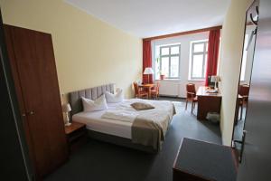 齐陶兹托尔霍夫酒店的配有一张床和一张书桌的酒店客房