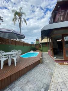邦比尼亚斯Vila Figueiredo das Donas的一个带桌椅的庭院和一个游泳池