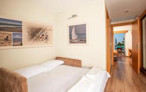 阿拉恰特阿拉恰特彩色别墅酒店的卧室配有两张床,墙上挂有图片