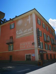 贝尔金Historisches Italienisches Hotel Piz Ela Bergün的一面有标志的红色建筑