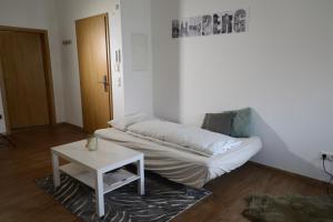 班贝格Pretti Apartments - NEUES stilvoll eingerichtetes Apartment im Zentrum von Bamberg的一间设有床铺和桌子的房间