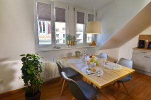班贝格Pretti Apartments - NEUES stilvoll eingerichtetes Apartment im Zentrum von Bamberg的一间带木桌和椅子的用餐室