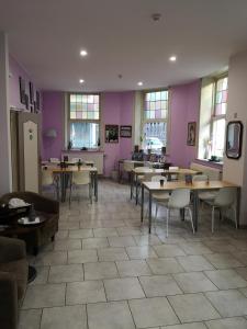 列日莱斯艾克特斯酒店的餐厅设有桌椅和紫色墙壁