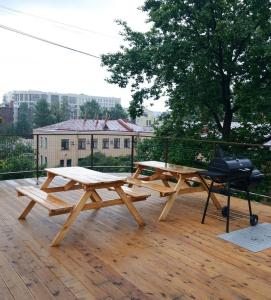 圣彼得堡UHOTEL的甲板上设有两张野餐桌和烤架