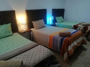 伊察Huacachina Desert House的酒店客房带两张床,还有蓝色的灯光