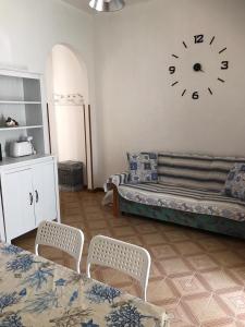 托雷坎内Appartamento Stella Maris的一间设有一张床和墙上一个时钟的房间