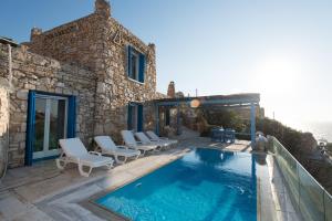 奥诺斯Villa Pirgaki的一个带椅子的游泳池以及一座房子