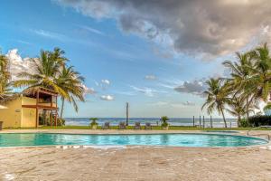 璜多里奥Marechiaro - Apartamento Vista Al Mar - Playa Juan Dolio的一座棕榈树和海洋游泳池