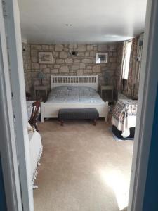 MarnhullThe Barn @ Hillside的一间卧室设有一张床和石墙
