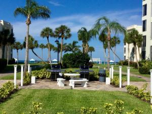 西耶斯塔岛Island House Beach Resort 24的棕榈树公园,桌子和长凳