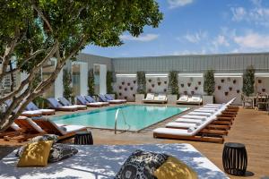 洛杉矶西好莱坞蒙德里安洛杉矶酒店的一个带躺椅的游泳池,一个度假村