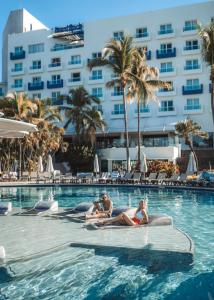 新巴利亚塔巴亚尔塔硬石全包度假酒店的一群人坐在酒店游泳池里