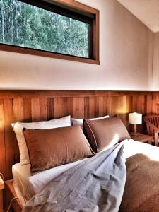 Southport南部森林度假屋的一间卧室配有一张床,楼上设有窗户