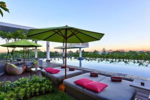 塞尔蓬塞尔彭阿拉姆舒特拉美居酒店的一个带两张沙发、一把遮阳伞和一个游泳池的庭院