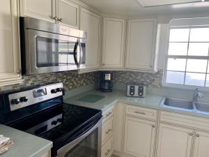 西耶斯塔岛Island House Beach Resort 9的厨房配有白色橱柜和炉灶烤箱。