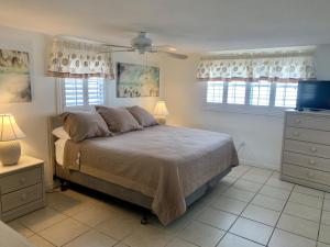 西耶斯塔岛Island House Beach Resort 9的一间卧室设有一张床和两个窗户。