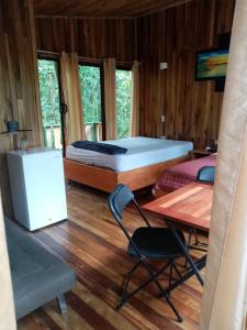 蒙泰韦尔德哥斯达黎加The Green Tree Lodge的配有一张床和一张桌子及椅子的房间