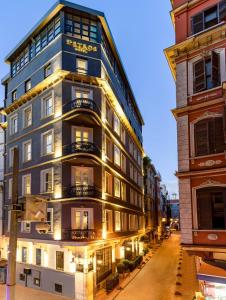 伊斯坦布尔Petros Hotel的夜幕降临的城市街道上一座高楼
