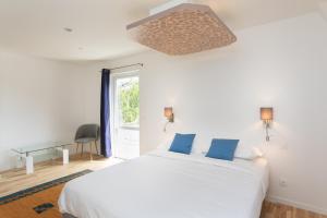 滨海卡约Chambre d'hôtes des pins的卧室配有白色的床和窗户。