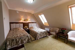 切尔诺夫策AllureInn Hotel and Spa的一间卧室设有两张床、一把椅子和窗户。