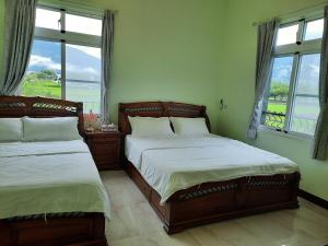池上米之颂民宿的卧室设有两张床,带两个窗户