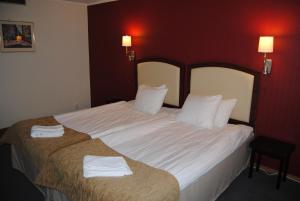 维纳什堡Arena Hotell的一间卧室配有一张大床和两条毛巾