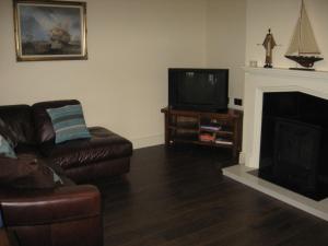 Irvinestown城堡景度假屋的带沙发和电视的客厅