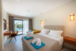 普雷韦扎Alonaki Resort的酒店客房 - 带一张床和一张带毛巾的书桌