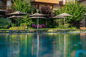 奥布佐尔HVD Club Hotel Miramar - 24 Hours Ultra All Inclusive的一个带遮阳伞和桌椅的游泳池