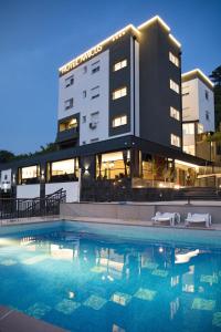 莫斯塔尔Hotel Amicus的大楼前设有游泳池的酒店