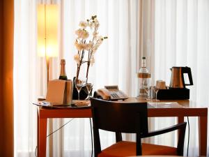 科隆贝尔伽瑞德南华欧酒店的一张带电话的桌子和一瓶葡萄酒