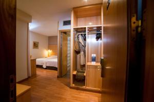 科尔多瓦Hotel Serrano的一间设有床铺的房间,一扇门通向一间卧室