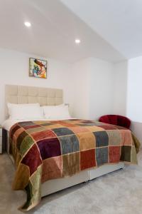 利兹Westwood Apartment的一间卧室配有一张带彩色毯子的床