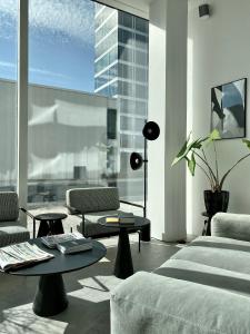 哥本哈根STAY Bryggen的客厅配有沙发、桌子和大窗户