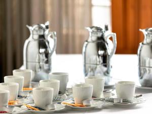 科隆贝尔伽瑞德南华欧酒店的桌子,上面有杯子,碟子和银罐